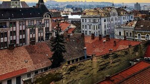 Panorama urbano con edifici storici e una guglia di chiesa ben visibile.
