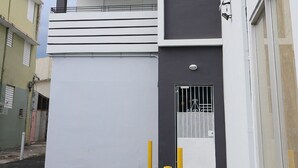 Een modern gebouw met twee verdiepingen, balkons en een hekwerk.