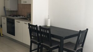 A kitchen with white cabinets, a black table, and four chairs.