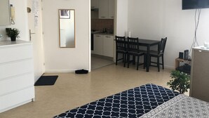 A modern apartment with a kitchenette, a dining area, and a living space.
