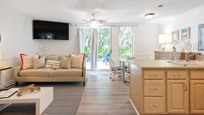 Ein modernes Wohnzimmer mit Sofa, Fernseher und Essbereich.
