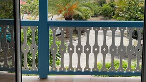 A covered balcony with a view of a garden and distant mountains. - Maison 90 m2 Pour 4 Personnes Avec Piscine Collective (Orient baie)