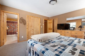 Cozy retreat with a large bed, flat-screen TV, and ample storage.
