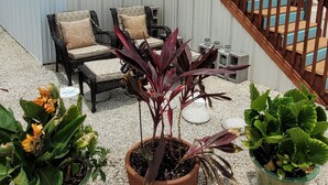 A house with a wooden staircase, outdoor seating, and potted plants. - Lower Keys paradise (Cudjoe Key)