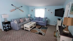 A living room with two sofas, a coffee table, a TV, and a wall-mounted TV. - Lower Keys paradise (Cudjoe Key)