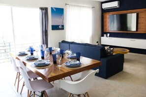 Ein Essbereich mit einem Holztisch, gedeckt für vier Personen, weißen Stühlen und blau-weißen Tellern.