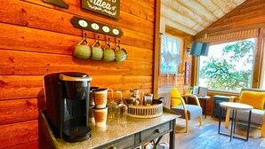 Ein gemütliches Holzinterieur mit einer Kaffeestation, einem Fernseher und einer Sitzecke mit Blick.