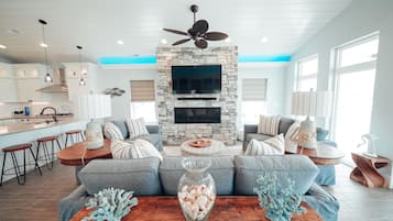 TV connectée, cheminée, livres, chaîne hi-fi