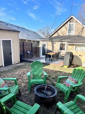 A backyard with a fire pit, green chairs, a table, and a covered grill area. - 2 bed, 2 bath West Plaza House, yard, parking! (Kansas City)