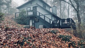 A modern two-story house with a balcony, surrounded by trees and covered in autumn leaves. - Rustic, Cozy Cabin with a View of the Smokies, Firepit, Large Deck, Pet-Friendly (Almond)