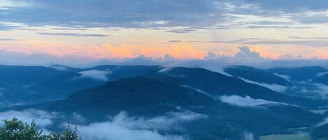 A mountainous landscape with a view of the sky at sunset.