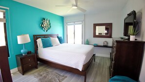 A bedroom with a bed, nightstand, dresser, and a ceiling fan.