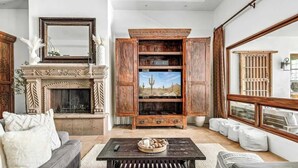 A living room with a fireplace, a television, a sofa, and a coffee table. - ParadiseValleyMillion$ Estate+Golf+Boccee+Casita (Paradise Valley)