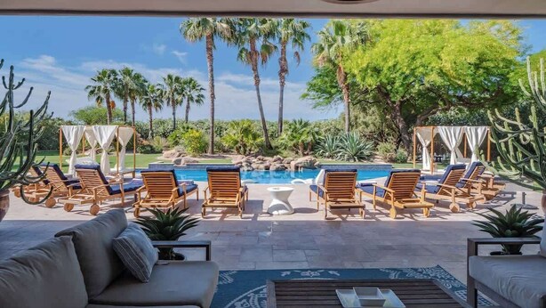 A poolside area with lounge chairs, a coffee table, and a view of a swimming pool and palm trees. - ParadiseValleyMillion$ Estate+Golf+Boccee+Casita (Paradise Valley)