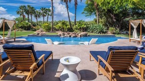A pool area with lounge chairs, a small table, and palm trees. - ParadiseValleyMillion$ Estate+Golf+Boccee+Casita (Paradise Valley)