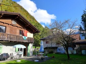 Eine Holzhütte mit Balkon, Sitzgelegenheit im Freien und Bergblick.