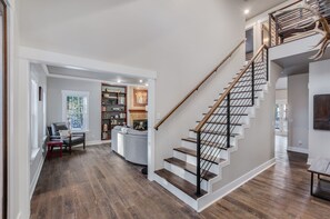 Stunning interior space with a modern staircase, leather sofa, and bookshelf.
