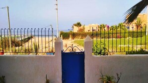 A view from a balcony with a blue gate, potted plants, and a clear sky. - Summer Center Imi Ouaddar 5389 (Imi Ouaddar)