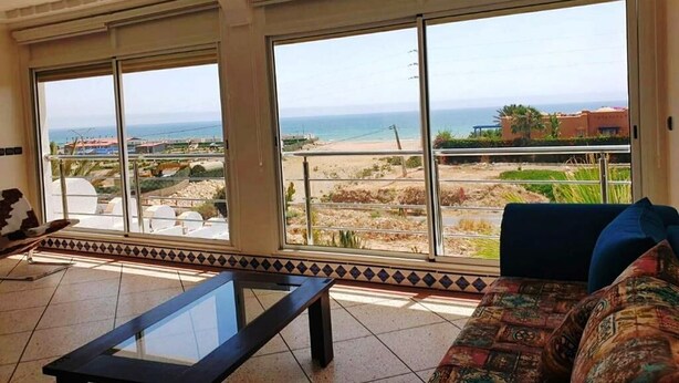 A living room with large windows, a sofa, and a coffee table. - Summer Center Imi Ouaddar 5389 (Imi Ouaddar)