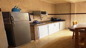 Une cuisine compacte équipée d’un réfrigérateur, d’un four à micro-ondes et d’une cuisinière.