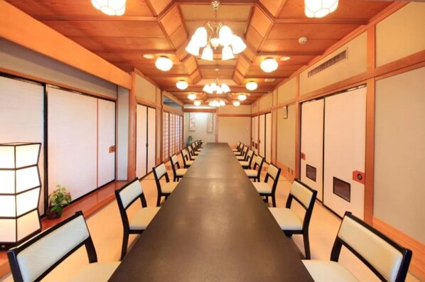 A conference room with a long table, chairs, and ceiling lights.