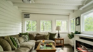 Ein gemütliches Wohnzimmer mit einem Ecksofa, einem Holztisch und einem Kamin.