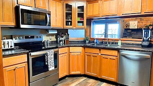 Una cocina moderna con gabinetes de madera, electrodomésticos de acero inoxidable y lavavajillas integrado.