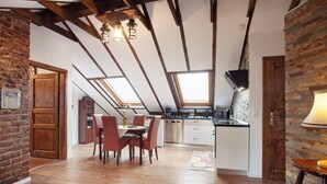 A loft-style kitchen with exposed beams, skylights, a dining area with chairs, and a bar stool. - Apartment "Haus Elena Wohnung 7A" with Mountain View, A/C, Wi-Fi, Garden & Terrace (Bestwig)