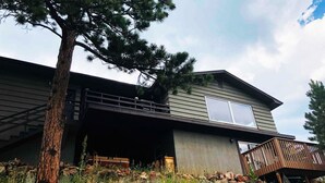 A modern two-story house with a covered porch and a large window.