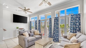 A spacious living room with a grey sofa set, a wooden coffee table, and a ceiling fan. - Unwind Your Mind...5 BR,4.5 baths...Book now for Summer (Panama City Beach)