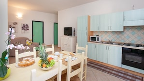 Une cuisine de taille réduite avec des meubles de couleur bleu clair, un four à micro-ondes et une cuisinière à gaz.