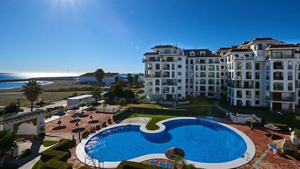 Un hotel con una piscina grande, vista sull'oceano e diversi edifici.