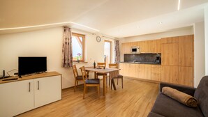 Un espacio habitable compacto con comedor, kitchenette y sofá.