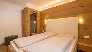 A modern bedroom with two beds, wooden paneling, and built-in lighting. - Holiday Apartment "Runcac Plaies" with Mountain View, Wi-Fi & Balcony (San Vigilio)
