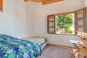 A bedroom with a bed, a window with curtains, a dresser, and a patterned rug. - Holiday Home Casa Caldereta with Mountain View, Pool, Wi-Fi & Terrace (Guatiza)