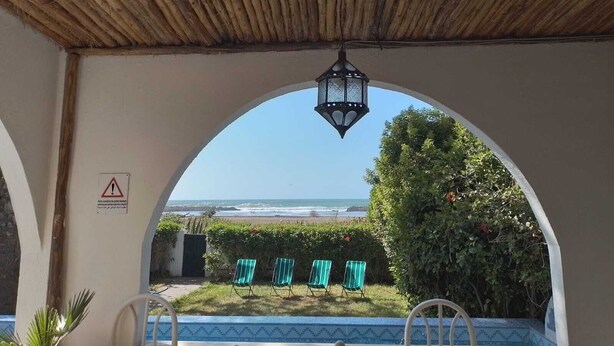 An outdoor seating area with a view of the beach and ocean.