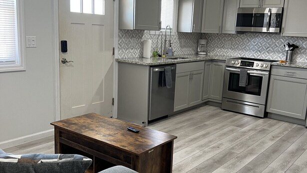 A modern kitchen with white cabinets, a stainless steel oven, and a microwave. - GOTL Strip Suite #3- Sunset Vacation Rentals (Geneva)