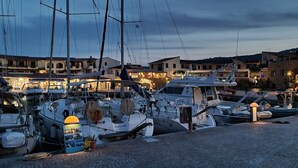 A marina with boats docked, buildings in the background, and a cobblestone path. - Villa LUNA ROSSA with Sea View, Pool, A/C, Wi-Fi, Garden, Terrace & Balcony (san teodoro)