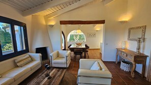 A cozy living room with a sofa, armchairs, a dining table, and a fireplace. - Villa LUNA ROSSA with Sea View, Pool, A/C, Wi-Fi, Garden, Terrace & Balcony (san teodoro)
