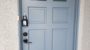 A blue door with a keypad lock, a peephole, and a keyhole. - The Deck House on the Silver Strand (Oxnard)