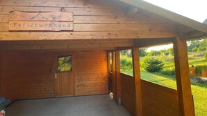 A wooden cabin with a sign reading "Ferienwohnung" and a covered porch. - Vacation apartment Hellerswiesen - Fewo Hellerswiesen (Bahretal)