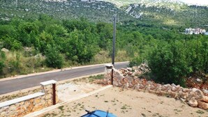 Una carretera con un muro de piedra y un objeto azul en el suelo.