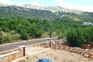 A road with a stone wall and a blue object on the ground. - Apartment in Starigrad near Paklenica Park (Seline)