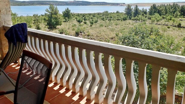 Un balcón con vistas a un lago y colinas.