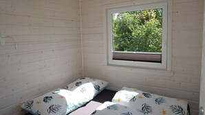 A small, single-room cabin with a window providing a view of greenery outside. - Bungalow in Kolczewo near Baltic Sea (Kolczewo)