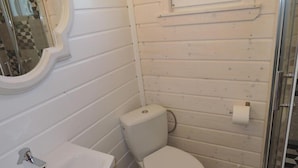 A small, white bathroom with a toilet, sink, and a mirror. - Bungalow in Kolczewo near Baltic Sea (Kolczewo)
