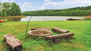 Area picnic sul lago con panche e un braciere.