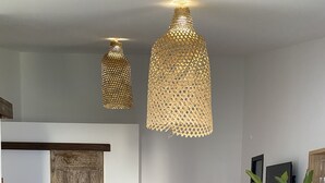 A modern kitchen with a wooden island, two bar stools, and hanging pendant lights. - L'Oasis de Saint-Jacques (SAINT DENIS)