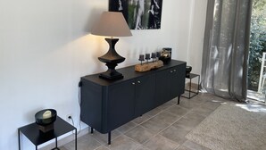 Una sala moderna con un mueble consola negro, una lámpara de pie y un cuadro abstracto de gran tamaño en la pared.