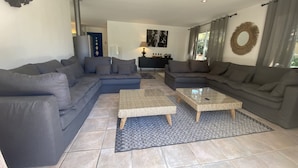 Una sala de estar moderna con un sofá modular, una mesa de centro y un televisor.